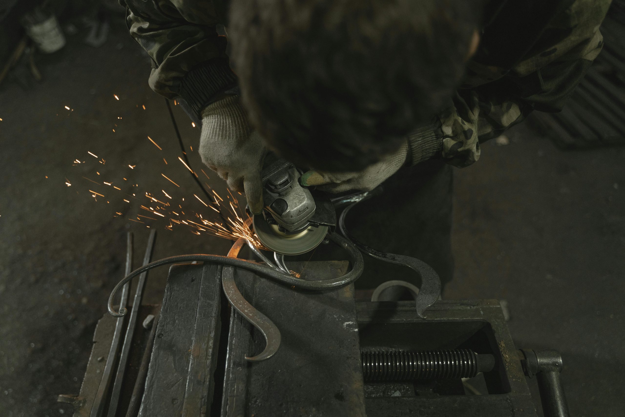 welder using angle grinder for fabrication work